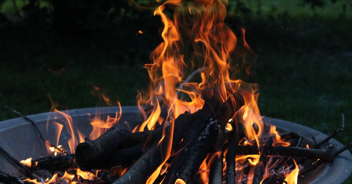 Smokeless fire pit glowing in a backyard at night